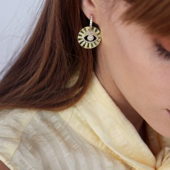 Perfil de mujer con aros argolla y detalle de ojo con cristales color oro