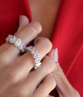 Mano de mujer con traje rojo y anillos platedos con cristales hermosos