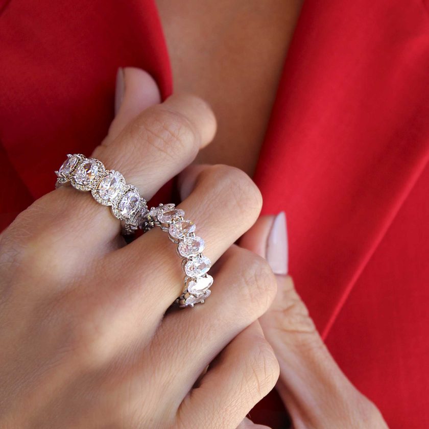 Mano de mujer con traje rojo y anillos platedos con cristales hermosos