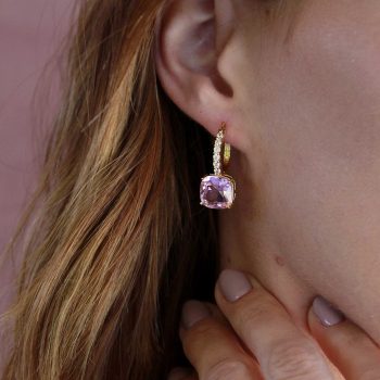 chica joven con bello par de argollas con bisagra con mini brillantes engarzados y pendiente de cristal cuadrado rosa