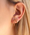 combinacion de argollas doradas en oreja de joven mujer